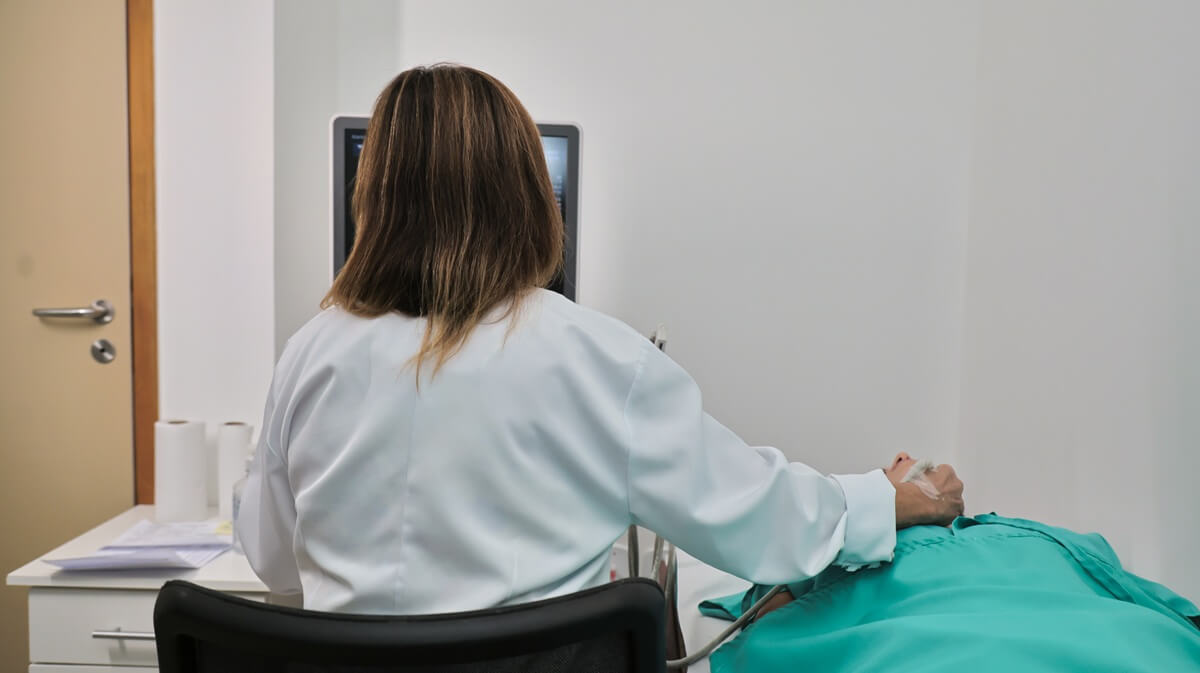 Profissional realizando exame de ultrassom com transdutor em contato com a pele do paciente na Lagos Scan, em Araruama