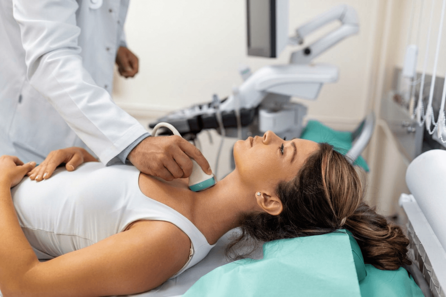 Médico a realizar ecografia Doppler das artérias carótidas e vertebrais no pescoço de uma paciente na clínica Lagos Scan.