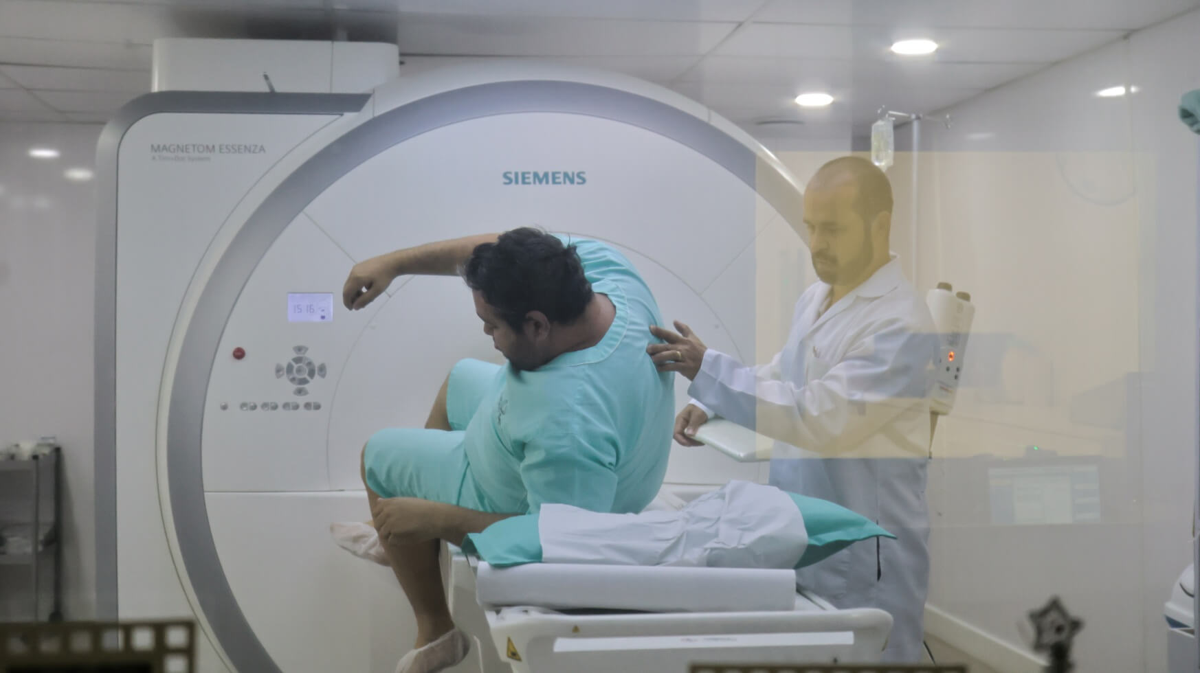 Paciente sendo orientado por profissional técnico antes do exame de artroressonância magnética na clínica Lagos Scan em Araruama.
