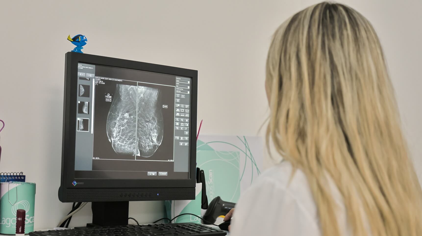 Radiologista a analisar exame de diagnóstico mamário na clínica Lagos Scan em Araruama durante a campanha do Outubro Rosa.