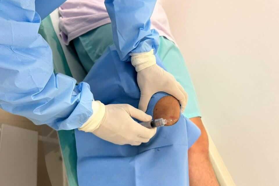 Médico especialista a realizar injeção articular guiada para artroressonância magnética de joelho na clínica Lagos Scan em Araruama.